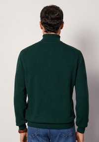 Mörkgrön, höghalset tröja i strukturerad stickad kvalitet, med långa ärmar och ribbade muddar och nederkant; designad för en avslappnad passform.