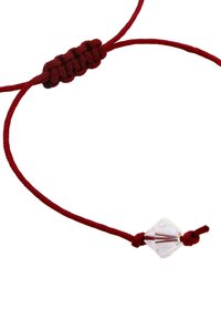 Bracelet en cordon rouge avec une perle en cristal clair facetté près d'un petit nœud, sur fond blanc.