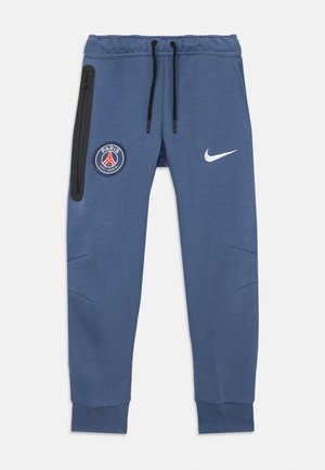 Pantalons de survêtement bleus du Paris Saint-Germain avec taille élastique, cordons de serrage noirs, poche latérale zippée, et logo Nike blanc sur la jambe droite.