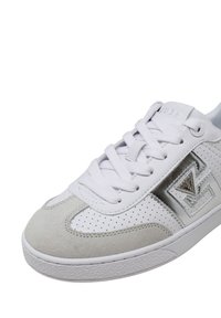 Sneaker Guess bianca e grigia con pelle perforata, punta in suede, lacci bianchi e logo metallico Guess sul lato.