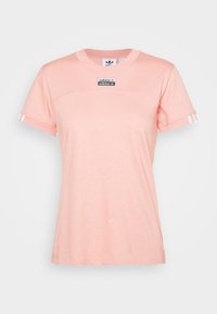 Rosa bomullströja med rund hals, har en svart etikett med logotyp och vita ränder på ärmarna. Slät textur, ledig passform.