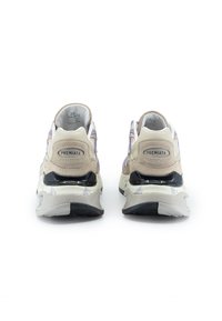 Beige Sneaker mit lila und grünen Akzenten, strukturiertes Wildleder und Mesh-Obermaterial, gepolsterte Sohle und gebrandete Fersenkappe. Schwarze Gummisohle.
