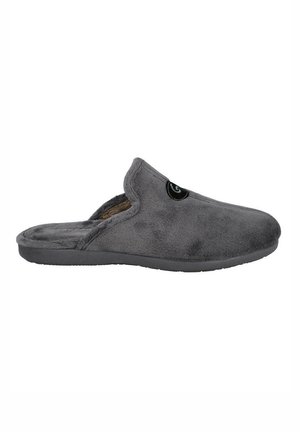 Zapatilla de casa gris y peluda con puntera redondeada, diseño slip-on y superficie texturizada. Presenta un acento de logo negro en el lateral y una suela plana.