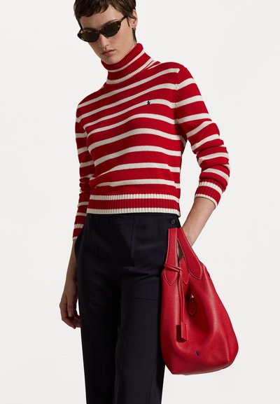 Sarkana un krēma svītrota augsta kakla džemperis ar pieguļošu dizainu. Tam pievienota teksturēta sarkana rokassoma, kura ir dekorēta ar akcentiem un norādi.