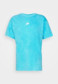 Světle modré bavlněné tričko s klasickým kulatým výstřihem, krátkými rukávy a malým bílým logem Nike na hrudi. Matný povrch.