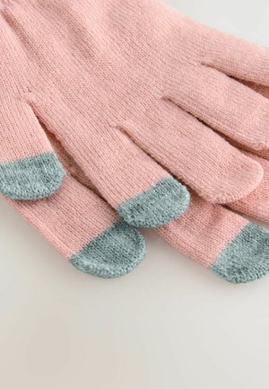 Vaaleanpunaiset neulotut hanskat, joissa on vaaleansinisiä kärkiä, aseteltu siististi vaalealle pinnalle, korostaen pehmeää tekstuuria ja rentoa tyyliä.