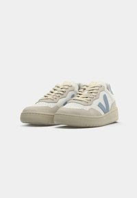 Sneakers med en hvit perforert skinnoverdel, beige semsket skinn detaljer og lyseblå side V-logo. Har en kremgummisåle. Klassisk design.