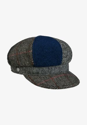 Herringbone wool flat cap with gray, navy blue, and red plaid panels, featuring a rounded crown and a short curved brim.