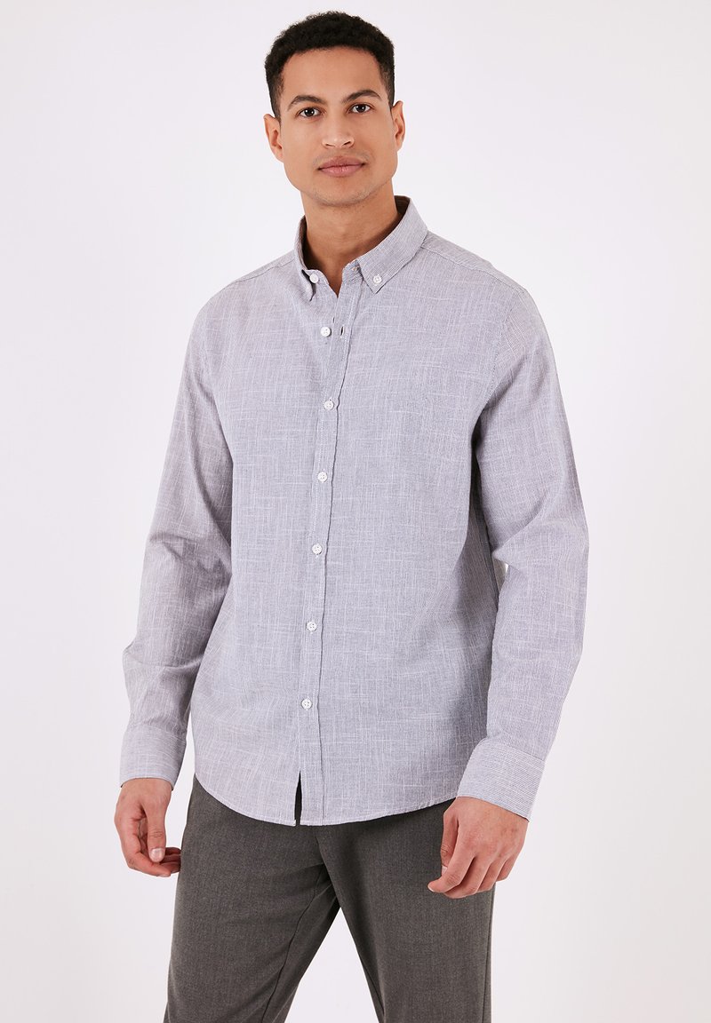 Világosszürke gombos ing finom textúrával, gombolt gallérral és hosszú ujjal. Slim fit szabás ívelt aljú.