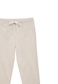 Beżowe spodnie dresowe z miękkiego, teksturowanego materiału, z elastycznym pasem na sznurku i bocznymi kieszeniami. Prosty krój bez widocznych wzorów.