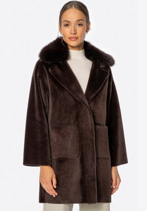 Brauner Kunstfellmantel mit weitem Kragen, langen Ärmeln und vorderen aufgesetzten Taschen. Glatte Textur mit lockerer Passform.