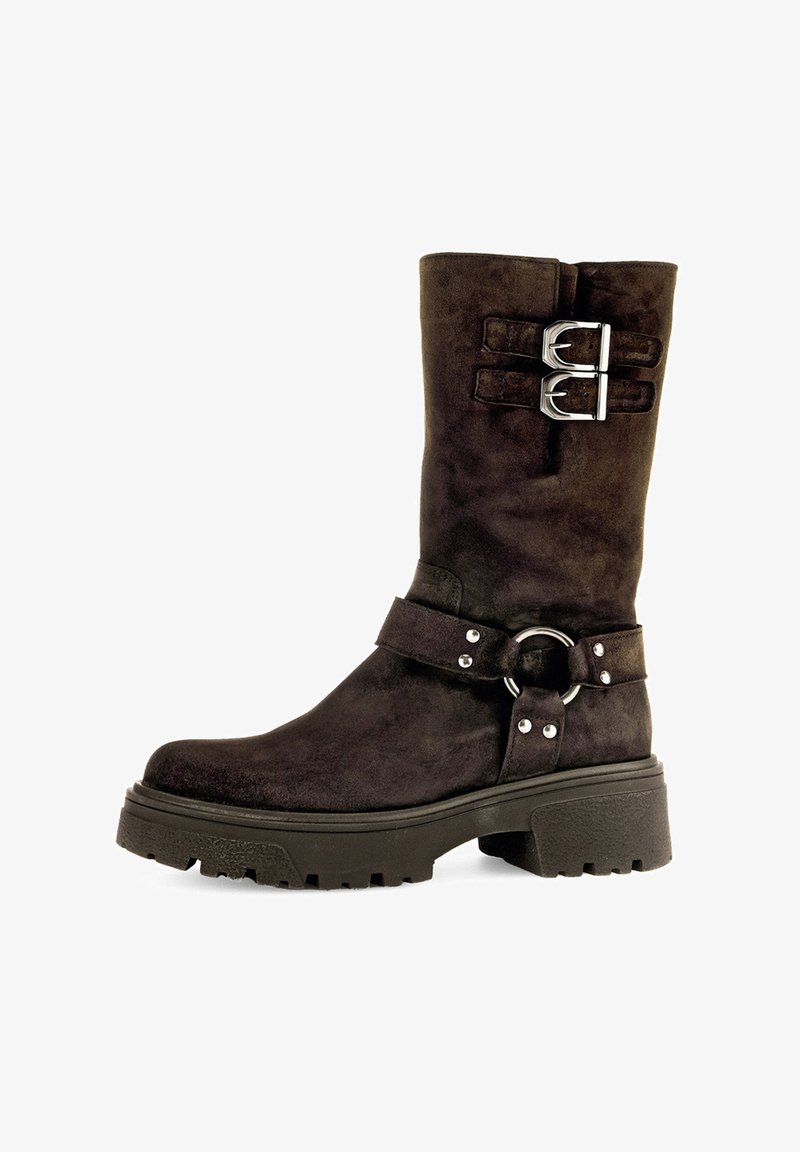 Bota de ante marrón oscuro hasta medio pantorrilla con dos hebillas plateadas en la parte superior, una correa con anillo de metal y remaches alrededor del tobillo, y suela gruesa.