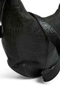 Sac à épaule en cuir noir avec une surface texturée, une forme incurvée et une large sangle. Détail de couture notable le long des bords.