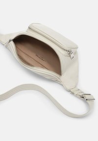 Bolso cruzado de cuero blanco con un compartimento con cremallera, mostrando un interior beige, una correa plana con detalles de costura y acentos en metal plateado.