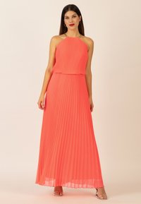 Faltendes Maxikleid in leuchtendem Koralle, mit Halterneck und gerüschtem Taillenbereich. Glatte Textur mit fließender Silhouette und Spaghetti-Trägern.