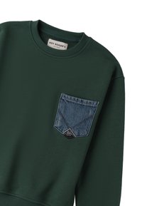 Felpa verde realizzata in morbido tessuto, con una tasca diagonale in denim blu caratterizzata da dettagli di cucitura e un'etichetta con il marchio nell'angolo.