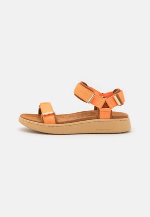 Casual sandal med orange stofremme, justerbare spænder i guldfarve, polstret brun fodseng og beige sål mærket Natural Soft.