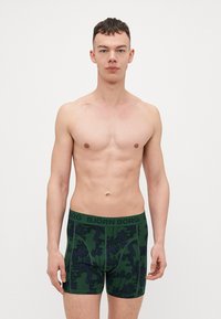 Zöld pamut boxer alsók sötét virágmintával, fekete rugalmas derékszíjjal, amelyen a "BJÖRN BORG" felirat található.