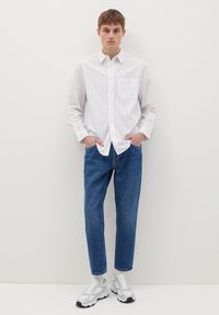 Wit gestreepte overhemden met borstzak, gecombineerd met blauwe spijkerbroek en witte sneakers. Casual pasvorm, modern ontwerp en lichtgewicht stof.