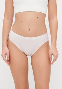 White cotton blend bikini briefs with a soft texture, low-rise design, and elastic waistband, featuring a smooth, seamless finish.