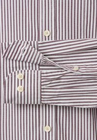 Langarmshirt met verticale witte en bordeauxrode strepen, met knoopmanchetten en witte knopen aan de voorkant.