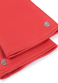 Rote Lederhandschuhe mit glatter Textur, die ein silbernes Totenkopf-Emblem am Bündchen haben. Eine gesteppten Detail entlang der Kanten sorgt für Struktur.