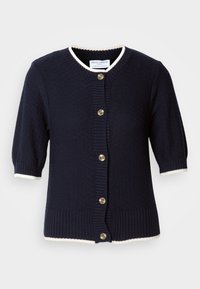 Cardigan en maille bleu marine à manches courtes avec bordure blanche et cinq boutons marron à l’avant.