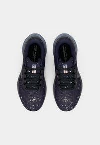 Pair of black and gray Nike running shoes with white speckled pattern viewed from above on a white background.