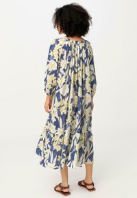 Maxikleid mit Blumenmuster auf navyblauem Hintergrund, gelben Blumen, langen Ärmeln und einem gestuften Rockdesign mit gerafftem Rücken.