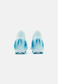 Light blue football boots with textured surfaces, white line patterns, and small studs on the sole. High-top design with a pull tab at the back.