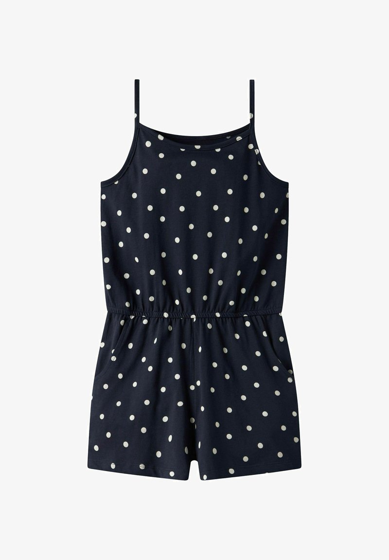 Smeđa kombinezonica s tankim naramenicama, bijelim točkicama, elastičnim pojasom i džepovima. Izrađena od mekanog materijala, ima opušteni kroj.