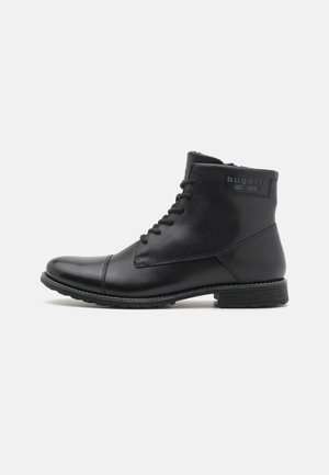 Schwarze Leder-Ankle-Boots mit runder Zehenpartie, Schnürverschluss und strukturiertem Gummisohle. Verfügt über dezente Markierung an der Seite und genähte Akzente.