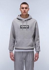 Felpa grigia con cappuccio e tasca frontale, dotata di una toppa logo in bianco e nero. Realizzata in tessuto morbido con una vestibilità comoda.