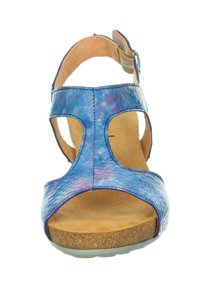 Blaue und lila gemusterte Ledersandale mit ausgeschnittenem Design, braunem Fußbett und verstellbarem Riemen. Korkähnliche Sohle sorgt für Griff.