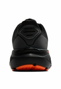 Scarpa da corsa nera con upper testurizzato, suola in gomma e accenti arancioni. Presenta un logo sul tallone e un colletto imbottito per supporto.