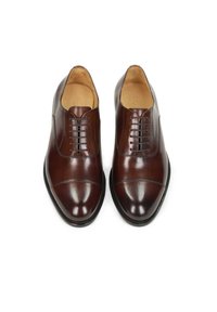 Scarpe eleganti in pelle marrone con una texture liscia, caratterizzate da un design con stringhe, punta arrotondata e sottili dettagli a punta rinforzata.