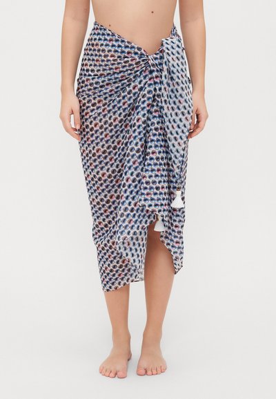 Wielokolorowa sarong z wzorem, wykonana z lekkiego materiału, z okrągłymi kształtami w kolorze niebieskim, różowym i białym, z ozdobnymi frędzlami na dole.