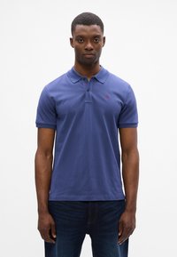 Polo blu navy in cotone, con colletto classico, maniche corte e un piccolo logo rosso sul petto.