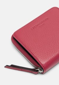 Rosa Lederbörse mit strukturiertem Finish, ausgestattet mit einem silbernen Reißverschluss und einem Leder-Zugband. Prägung des Logos auf der Vorderseite.