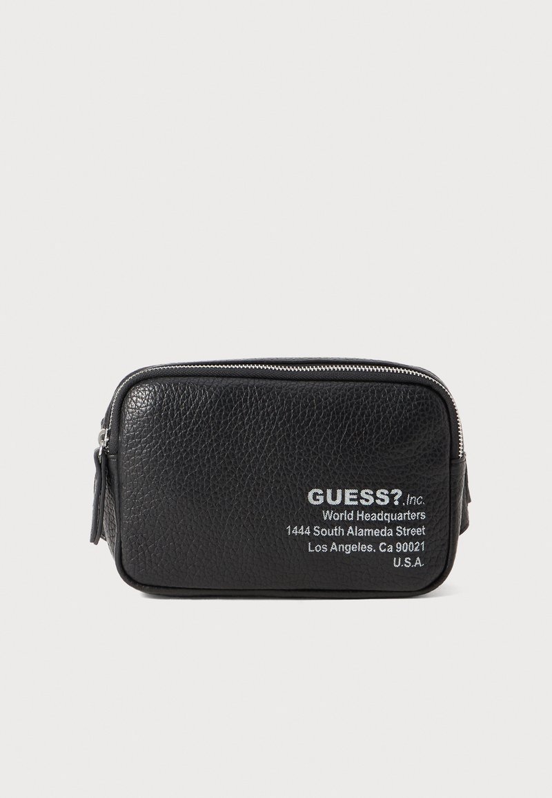 Schwarze, strukturierte Ledertasche mit silbernem Reißverschluss, auf der Vorderseite mit aufgedrucktem weißem Logo und Adressdetails. Kompakte rechteckige Form.