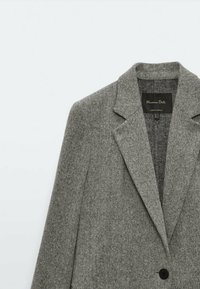 Szary żakiet w jodełkę z wełny z wykładanymi klapami, jednym czarnym guzikiem i metką Massimo Dutti wewnątrz kołnierza.