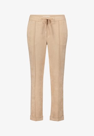 Pantalons de jogging beiges en matériau doux semblable à du daim, avec une taille élastique dotée d'un cordon de serrage et des ourlets à resserrement. Détails de couture verticaux.