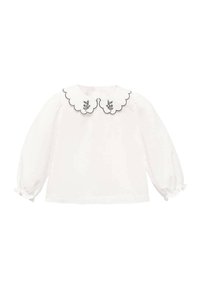 Vit långärmad blus med en scalloped krage som har blommig broderi och svart kant, mjukt tyg, draperade manschetter och en rundad nederkant.