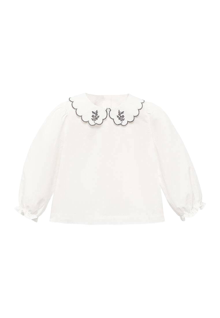 Vit långärmad blus med en scalloped krage som har blommig broderi och svart kant, mjukt tyg, draperade manschetter och en rundad nederkant.