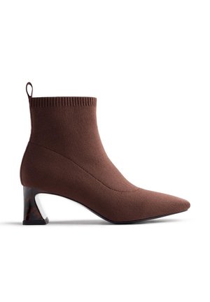 Botte de cheville marron avec une texture en tricot, bout pointu et un talon géométrique unique avec un accent en écaille de tortue.