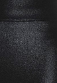 Svart texturerad tyg med ett subtilt mönster, som visar små upphöjda prickar. Slät och elegant i utseendet, lämplig för olika användningsområden.