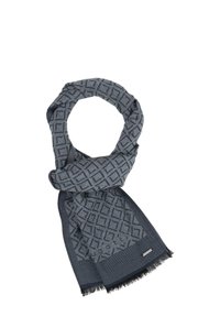 Bufanda azul con un patrón geométrico, hecha de tela suave, terminada con flecos y con una etiqueta de marca discreta.