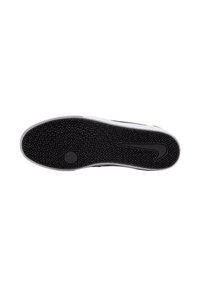 Black rubber shoe sole with a zigzag pattern and a smooth white edge. Features a central circular emblem and a subtle logo on the side.