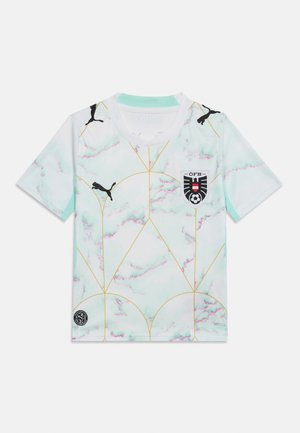 Λευκή και ανοιχτό τιρκουάζ αθλητική φανέλα με χρυσές γεωμετρικές γραμμές, μαύρα λογότυπα Puma και το έμβλημα της ποδοσφαιρικής ομάδας της Αυστρίας στο στήθος.