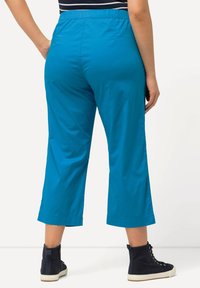 Blå, korta byxor i lätt material, med elastiskt midjeband och rak bendesign med sidslitsar vid nederkant.